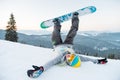 Excited young snowboarder woman having fun on the slope lying on the snow with her legs in the air Royalty Free Stock Photo