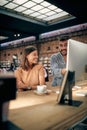 Excited young teammates working together on desktop computer. Young man and woman colleagues in clothing shop working on project Royalty Free Stock Photo