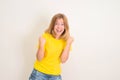 Excited young teenager girl standing isolated over white background make winner gesture. People, teen, emotions, expressions,