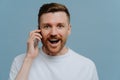 Overjoyed man receiving good news while talking with somebody on mobile phone Royalty Free Stock Photo