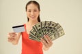 Excited young woman with cash money and credit card on gray background Royalty Free Stock Photo