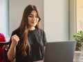 Excited young woman celebrating online win success looking at laptop at cafe Royalty Free Stock Photo