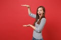 Excited young woman gesturing demonstrating size with copy space, keeping mouth wide open, looking surprised isolated on