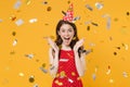 Excited young woman girl in red summer dress birthday hat isolated on yellow wall background studio portrait. Birthday Royalty Free Stock Photo