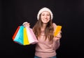 An excited young woman about her online shopping. She is holding some colourful bags and her phone. Royalty Free Stock Photo