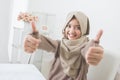 Excited young woman with hijab smiling to camera and showing thu Royalty Free Stock Photo