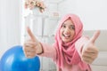 Excited young woman with hijab smiling to camera and showing thu Royalty Free Stock Photo