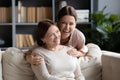 Excited young woman hugging older mother, family having fun