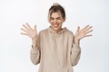 Excited young woman jumping from happiness, shaking raised hands and smiling with joy, standing happy against white Royalty Free Stock Photo