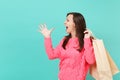 Excited young woman in knitted pink sweater spreading fingers, holding in hand packages bags with purchases after Royalty Free Stock Photo