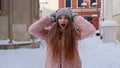 Excited young woman looking to camera, opening her mouth in amazement, shouting wow on city street Royalty Free Stock Photo