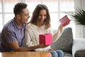 Excited young woman opening gift box receiving present from husband Royalty Free Stock Photo