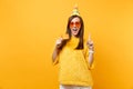 Excited young woman in orange heart glasses, birthday hat pointing index finger up, holding credit card celebrating