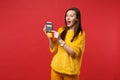 Excited young woman in yellow fur sweater hold wireless modern bank payment terminal to process and acquire credit card Royalty Free Stock Photo