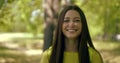 Exciting brunette in yellow top smiles standing in park