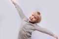 Exciting fair-haired boy playing airplane. Portrait of child on white background