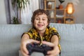 Close up portrait of emotional little boy playing video games on gamepad, pushing buttons on joystick Royalty Free Stock Photo