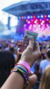 Exciting Outdoor Music Festival Atmosphere with Concert Ticket in Hand