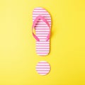 Exclamation mark made of beach slippers on yellow background. Summer minimal concept