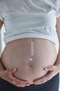 Exclamation mark painted with body cream on pregnant woman`s belly Royalty Free Stock Photo