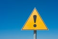 Exclamation mark on a yellow road sign. Against the blue sky Warning, danger Royalty Free Stock Photo