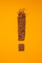 Exclamation point shape of buckwheat groat on orange background