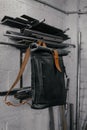 Exclusive black leather backpack. Backpack near the wall. The tools in the garage. Metal pipes near the wall Royalty Free Stock Photo