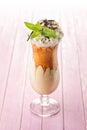 Exclusive coffee cocktail with caramel topping on glass with cream and mint leaf, on white background, frappe Royalty Free Stock Photo
