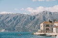 Excursion boat is moored to the coast with ancient stone houses. Perast, Montenegro Royalty Free Stock Photo