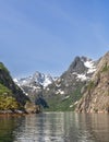 An excursion boat sails through the narrow Trollfjorden in the Lofoten Islands Royalty Free Stock Photo