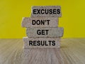 Excuses don\'t get results symbol. Brick blocks with words excuses don\'t get results on beautiful yellow background