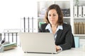 Executive adult lady working on laptop at office