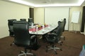 Executive board room set up with white paper, pen, botle of water, glass, flowers and screen