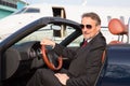 Executive business man in a cabriolet in front of corporate priv Royalty Free Stock Photo