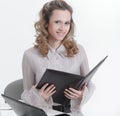 Executive female assistant with documents standing near desktop.