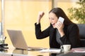 Executive on the phone celebrating news with laptop