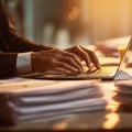 Executive\'s focused computer work amidst a pile of documents in warm ambiance Royalty Free Stock Photo