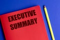 Executive summary text on red notebook with yellow pencil on blue background Royalty Free Stock Photo