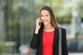 Executive talking on phone looking at camera on the street