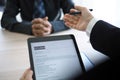 Executives are interviewing candidates and holding a tablet, opening the resume from the email that the applicant submits online. Royalty Free Stock Photo