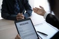 Executives are interviewing candidates and holding a tablet, opening the resume from the email that the applicant submits online. Royalty Free Stock Photo