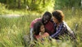 Exemplary couple dedicate their free time to only child, relaxing in summer park Royalty Free Stock Photo