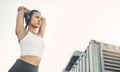 Exercise, city and woman with headphones, fitness or wellness with training, podcast and stress relief. Female person