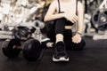 Exercise concept The female with dark tone of outfits resting herself on the black carpet floor after playing on the dumbbell