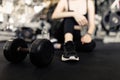 Exercise concept The female with dark tone of outfits resting herself on the black carpet floor after playing on the dumbbell