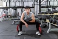 Exercise concept The muscular guy in grey sport top and black pants and a black smartwatch working out with the dumbbell by doing Royalty Free Stock Photo