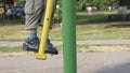 Exercise gyms in the open air. child has a simulator. Legs in sandals swing on a pendulum.