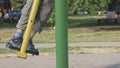 Exercise gyms in the open air. child has a simulator. Legs in sandals swing on a pendulum.