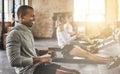 Exercise, happy man and rowing machine in gym for group class, fitness workout and cardio training. African bodybuilder Royalty Free Stock Photo