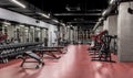 Exercise machines and racks with sets of black weights by the mirror in empty gym interior. Special equipment for
